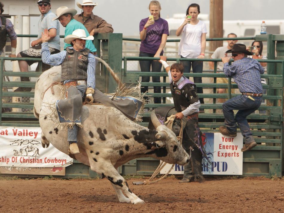 A man hangs on tight to his bucking bull during the 2015 Klickitat County Fair Rodeo.