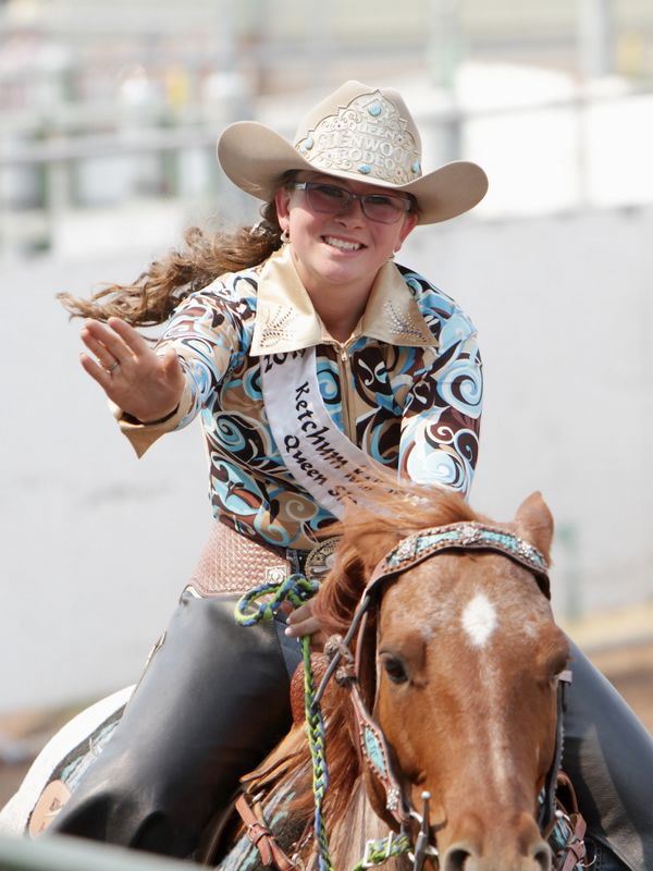 The Glenwood Rodeo Queen waves to the crowd as she rides by on her horse.