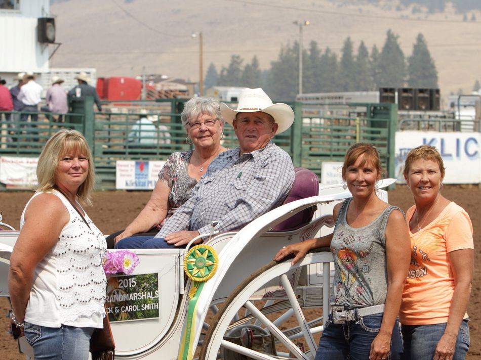 People pose next to the white wagon carrying the 2015 Grand Marshals.
