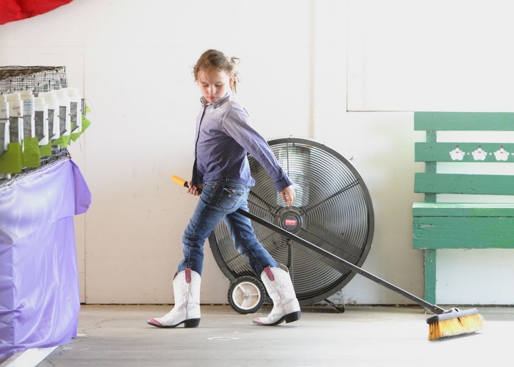 A little girl walks with a broom at the 2014 Klickitat County Fair.