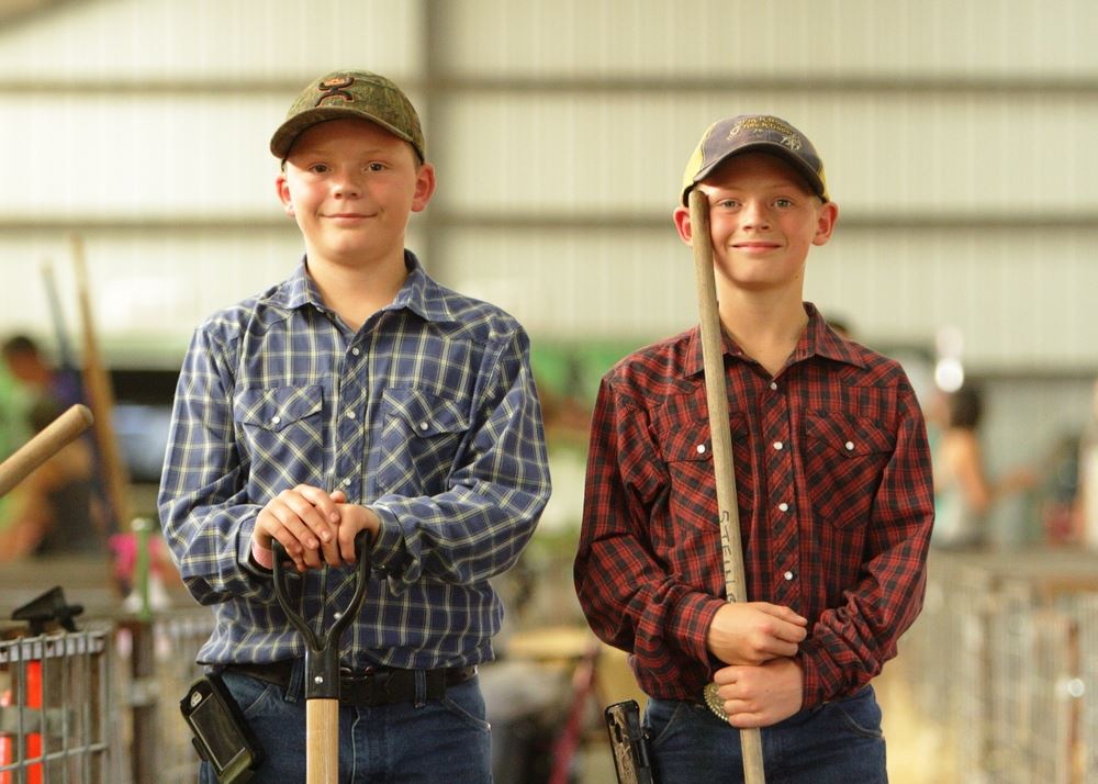 Two boys clean up the animal pens at the 2014 Klickitat County Fair.
