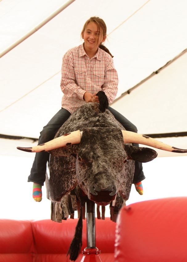 A girl gets ready to attempt a ride on the mechanical bull at the 2014 Klickitat County Fair.