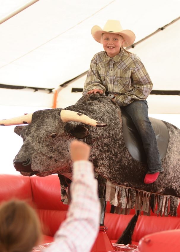 A little girl gets ready to attempt a ride on the mechanical bull at the 2014 Klickitat County Fair.