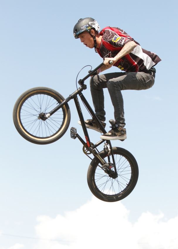 A man does tricks on his BMX bike.