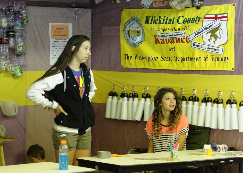 Two girls sit at the Waste Reduction exhibit at the 2014 Klickitat County Fair.