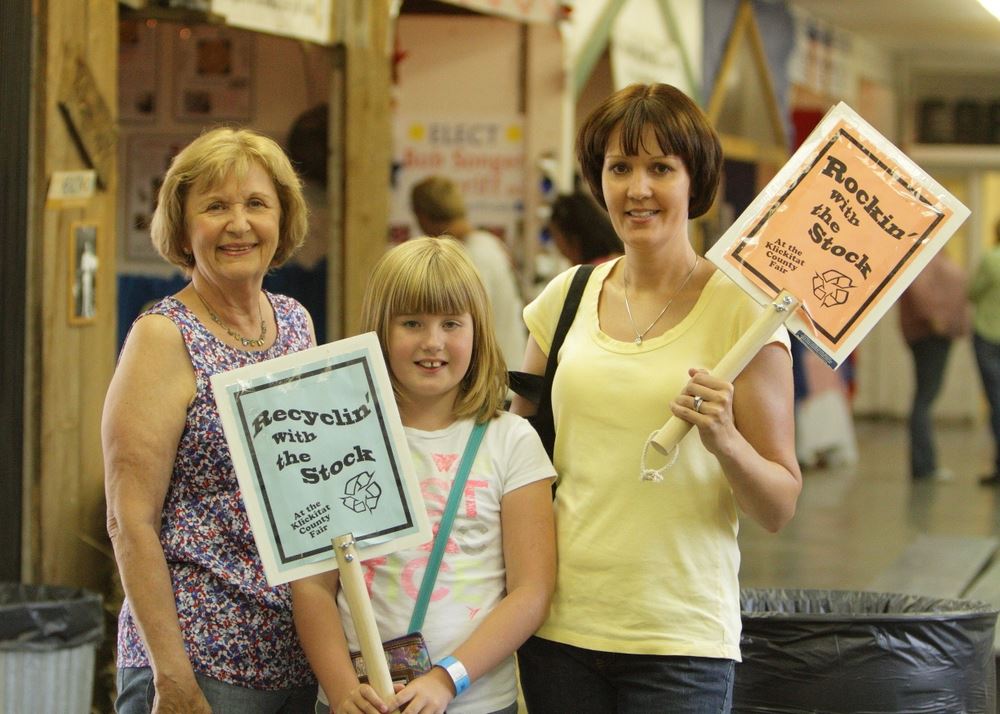Two women and a little girl pose with Rockin' with the Stock signs.