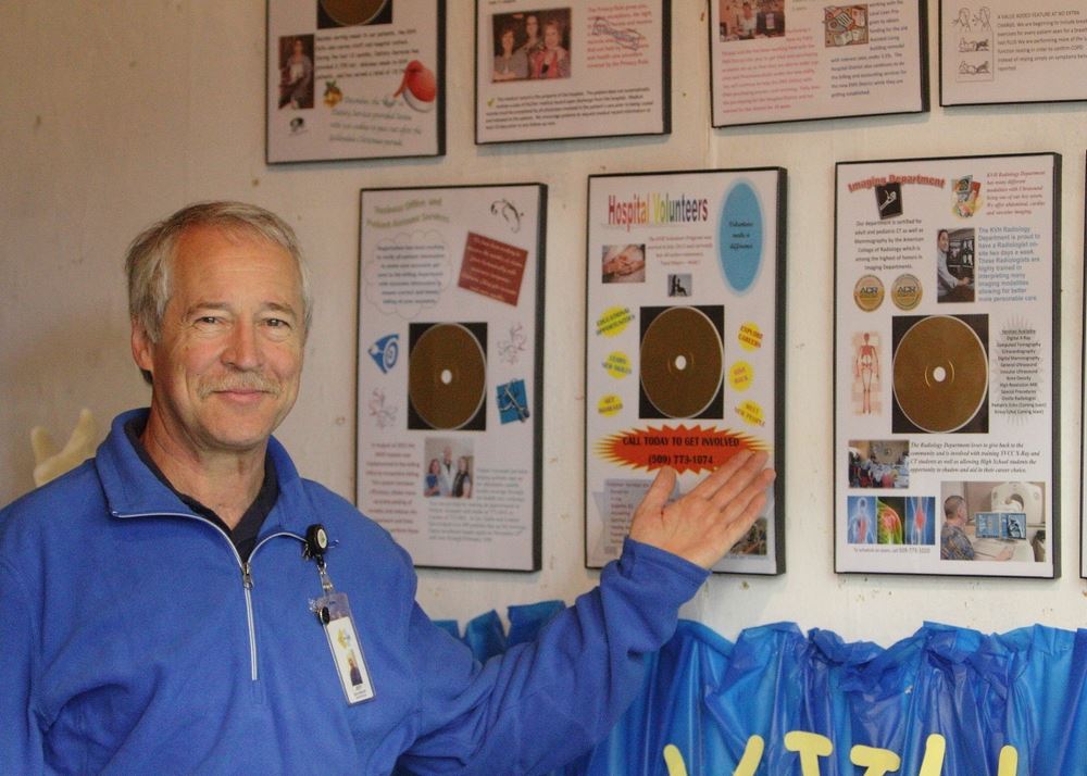 A man shows framed pieces in an exhibit at the 2014 Klickitat County Fair.