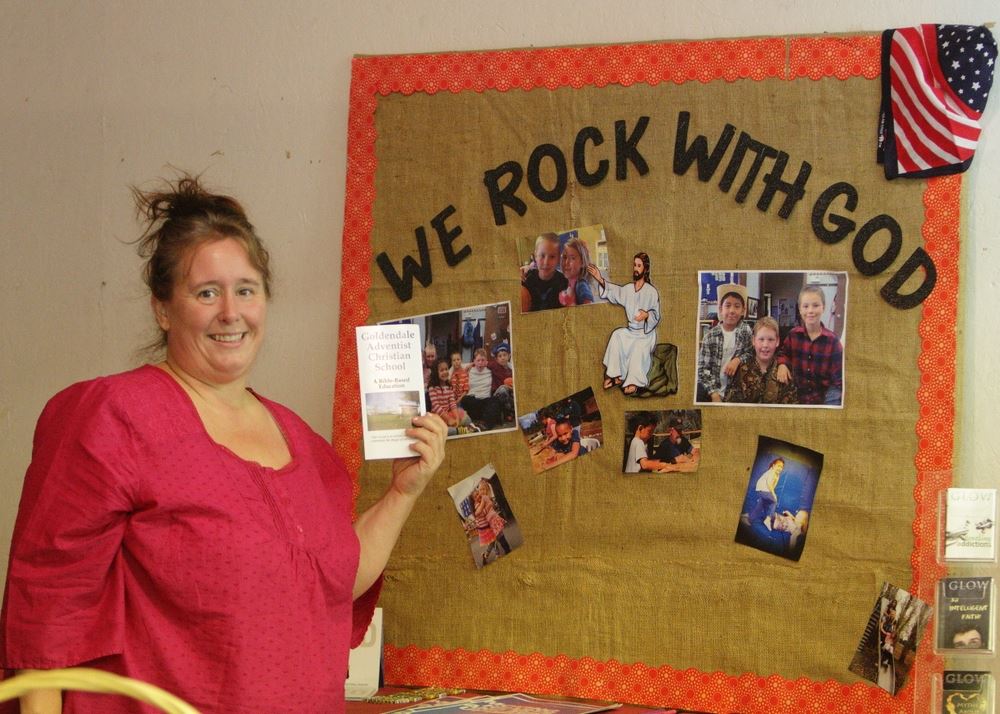 A woman stands at the We Rock with God exhibit.