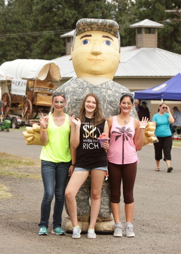 Three girls pose with the blow up Army man.
