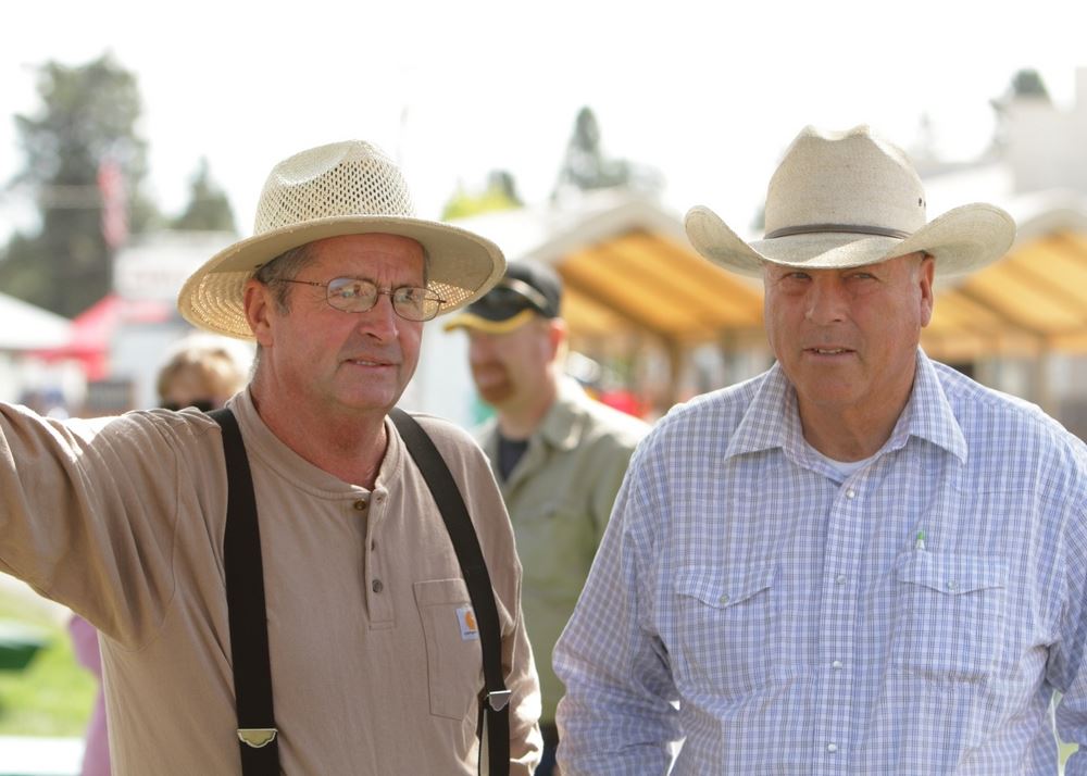 Two men with cowboy hats on stand together at the 2014 Klickitat County Fair.