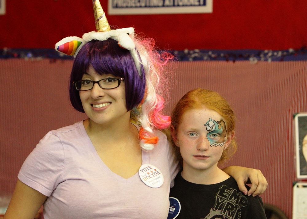 A woman with a unicorn wig and a little gir with face paint smile at the 2014 Klickitat County Fair.