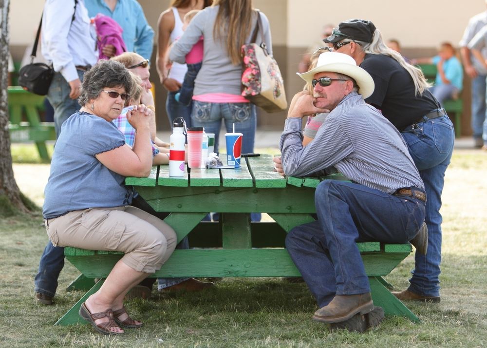 A group of people sit together at a picnic table.