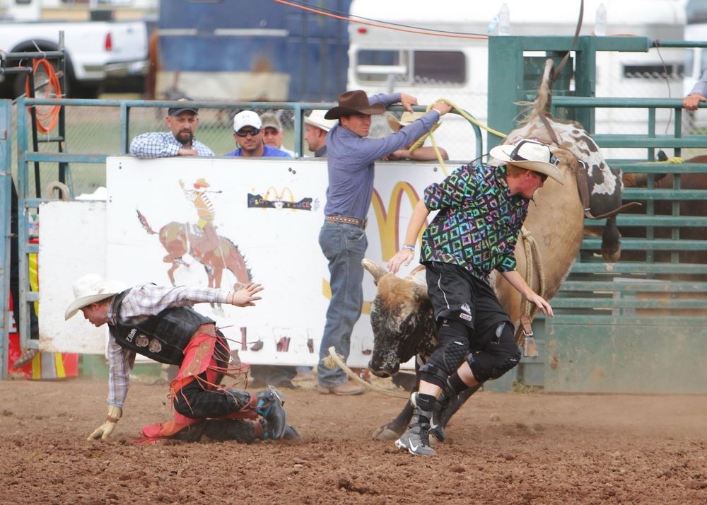A man runs to safety from as a bucking bull is distracted at the 2014 Klickitat County Fair Rodeo.