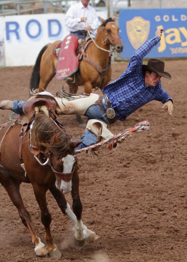 A man leaps from a bucking horse at the 2014 Klickitat County Fair Rodeo.