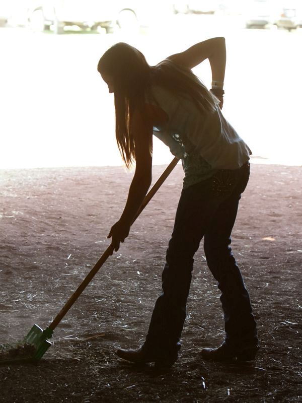 Girl cleans up after the animals in the animal barn at the Klickitat County Fair.