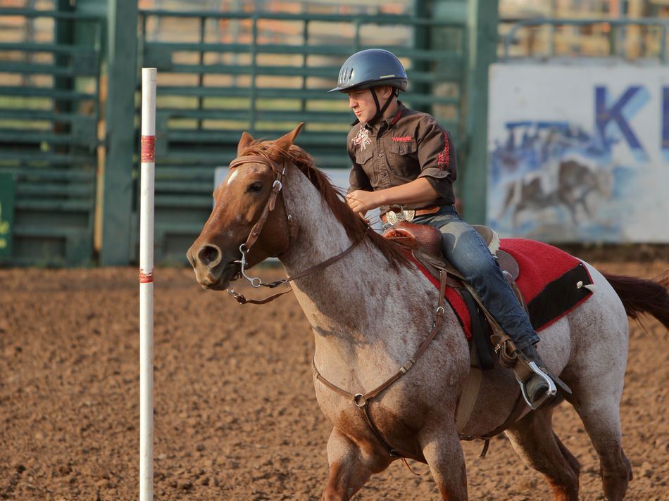 A young man runs his horse around a pole at the 2015 Klickitat County Fair.