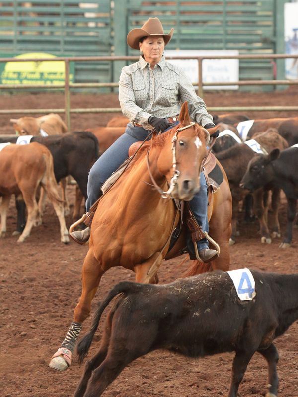 A woman runs her horse to herd a calf at the 2015 Klickitat County Fair.
