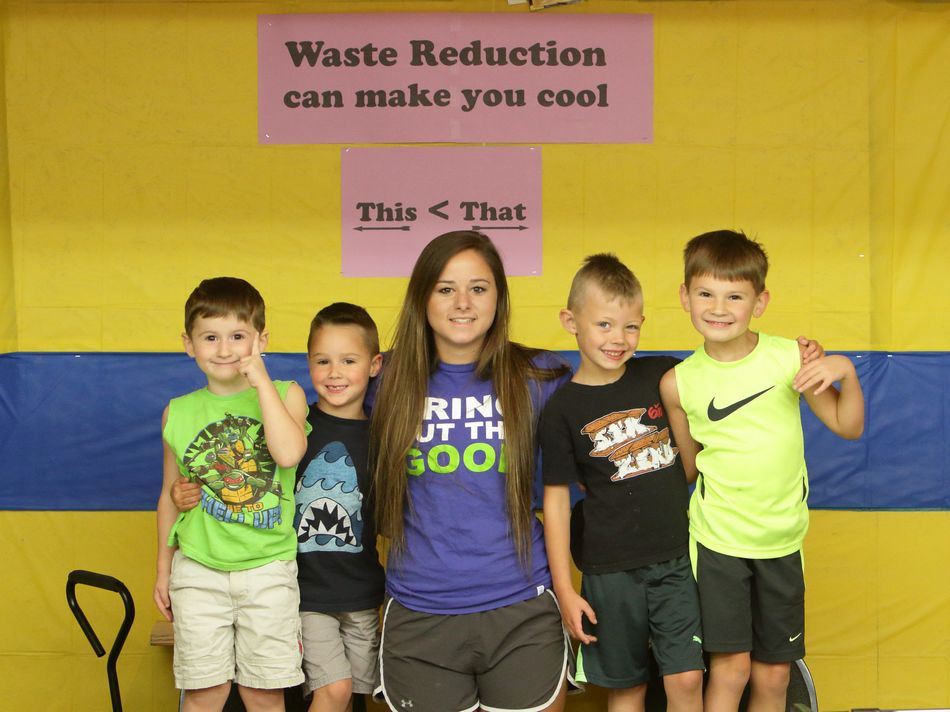 A group of little boys pose with an older girl at the Waste Reduction exhibit.