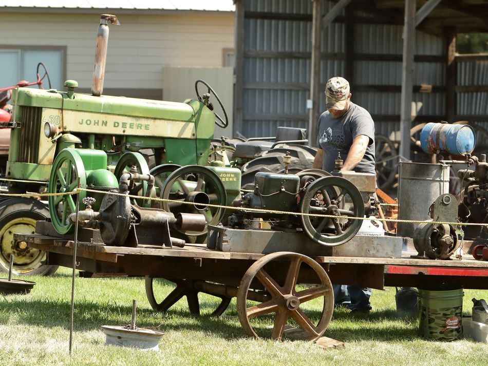 Man looks at old tractor parts.