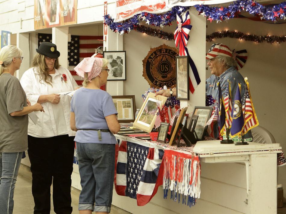 A woman shows a picture to onlookers at a booth at the Klickitat County Fair.