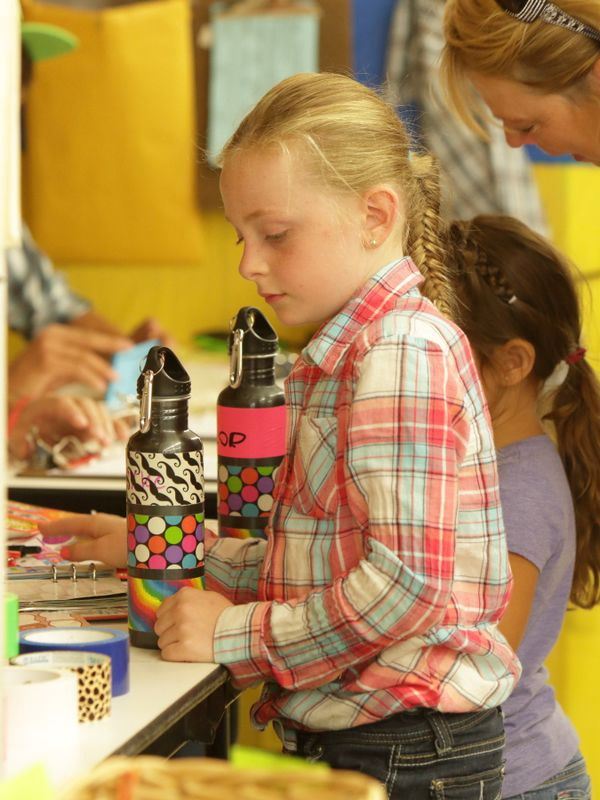 Little girl stands at the Waste Reduction exhibit.